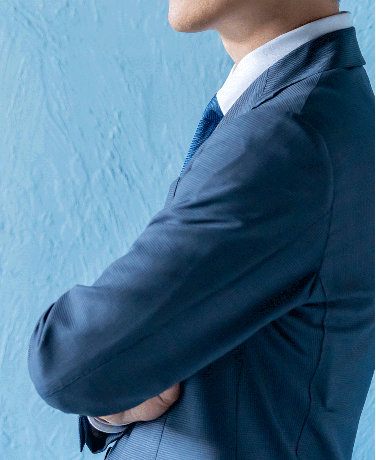 スーツ姿で腕を組む男性